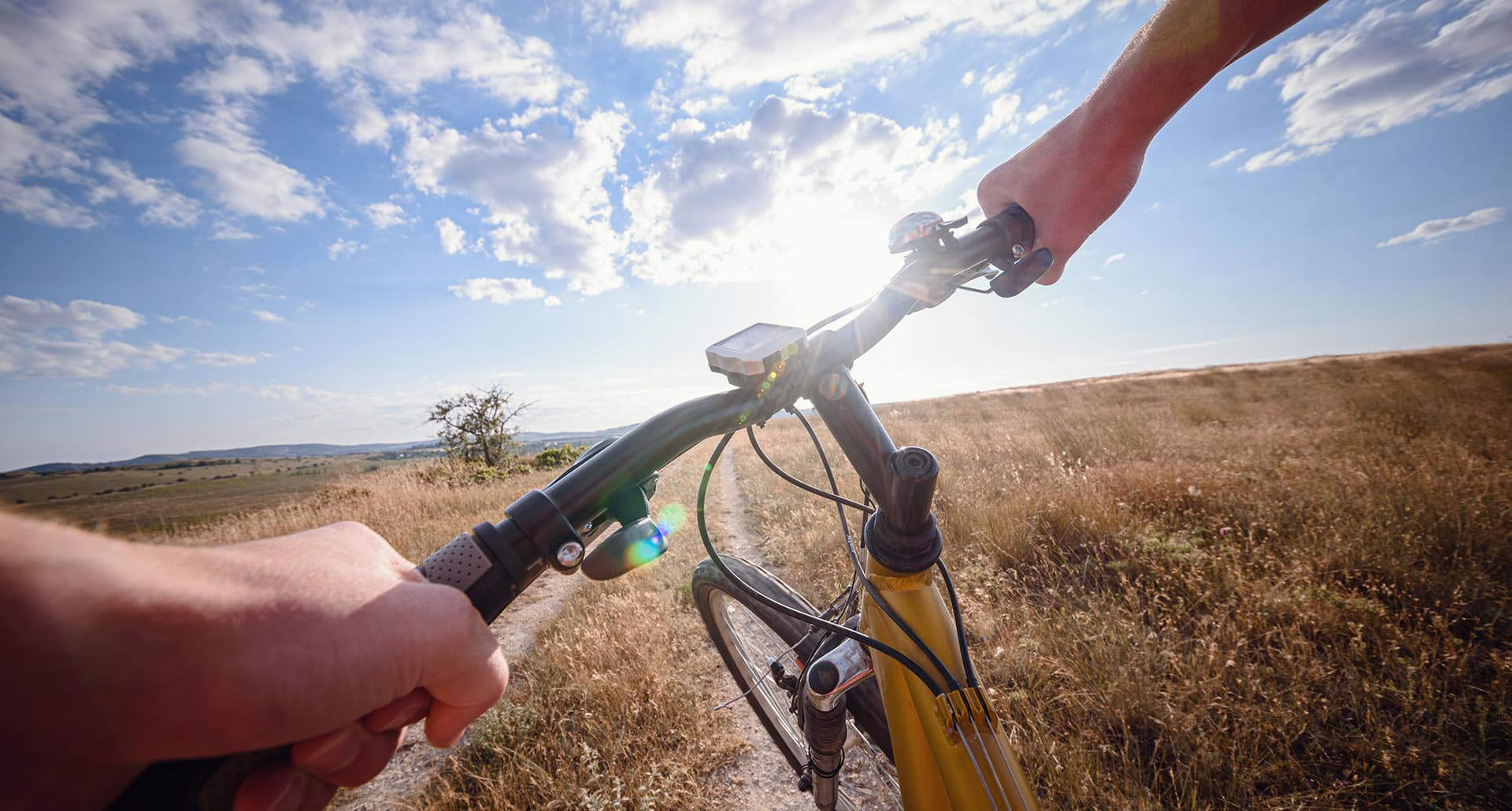 Bike Handle Bar With Lake And Sunshine In The Background.